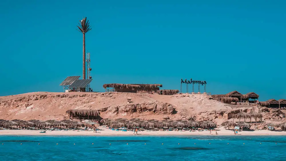 Mahmya Strand in Giftun Island mit Liegestühlen, Sonnenschirmen und einem Restaurant