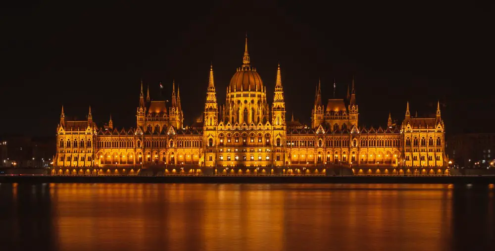 Parlament in Budapest in der Nacht vom Donauufer aus gesehen. 