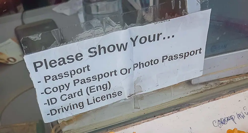 Please Show Your Passport Aufschrift am Eingang einer Wechselstube in Thailand