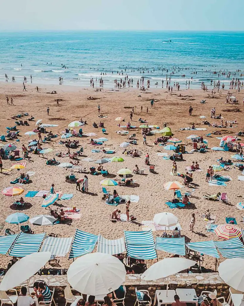 Strand mit Sonnenliegen, Sonnenschirmen und dem Meer in Spanien