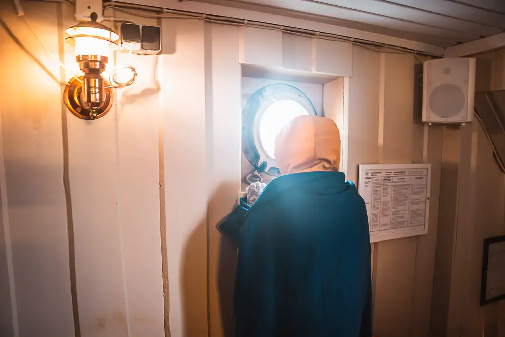 Kind schaut aus dem Fenster von einem Schiff auf dem Oslofjord in Norwegen Kind schaut aus dem Fenster von einem Schiff auf dem Oslofjord in Norwegen
