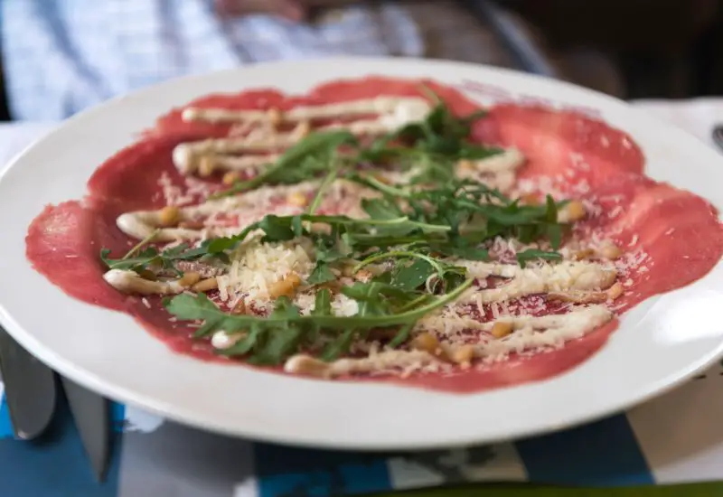 Ein Teller mit der Speise Carpaccio aus Italien Ein Teller mit der Speise Carpaccio aus Italien
