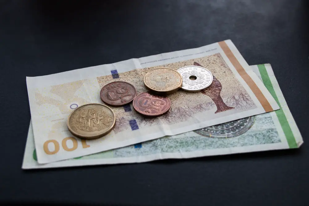 Geldscheine und Münzen aus Dänemark liegen auf einem Tisch Geldscheine und Münzen aus Dänemark liegen auf einem Tisch